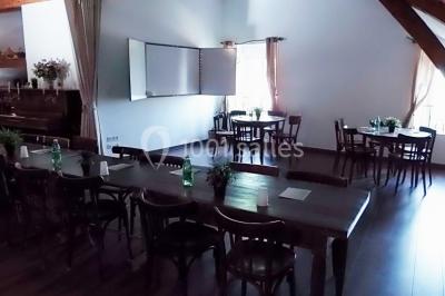 Chambre lumineuse avec murs jaunes, deux lits simples, décorations florales et une peluche sur un lit.