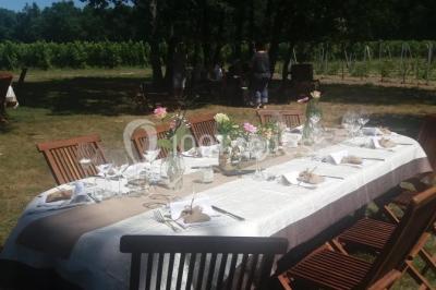 Bouteille de vin rouge dans une caisse en bois ouverte, posée contre un mur en pierre.