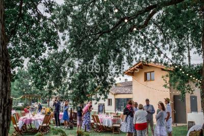 Bouteille de vin rouge dans une caisse en bois ouverte, posée contre un mur en pierre.