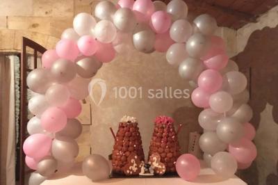 Bouteille de vin rouge dans une caisse en bois ouverte, posée contre un mur en pierre.