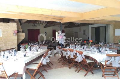 Bouteille de vin rouge dans une caisse en bois ouverte, posée contre un mur en pierre.