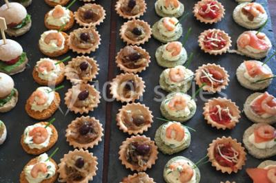 Bouteille de vin rouge dans une caisse en bois ouverte, posée contre un mur en pierre.