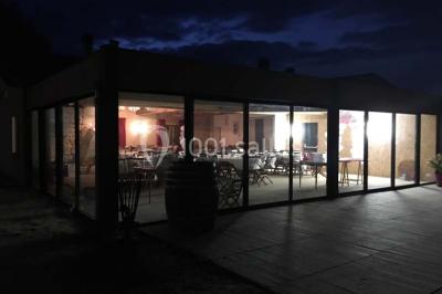 Espace extérieur décoré avec guirlandes lumineuses, fauteuils et tonnelle, au crépuscule dans un jardin.