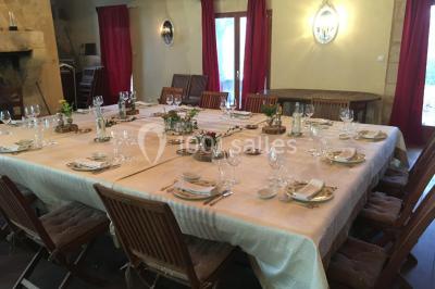 Espace extérieur décoré avec guirlandes lumineuses, fauteuils et tonnelle, au crépuscule dans un jardin.