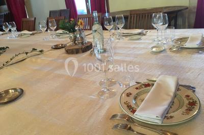 Espace extérieur décoré avec guirlandes lumineuses, fauteuils et tonnelle, au crépuscule dans un jardin.