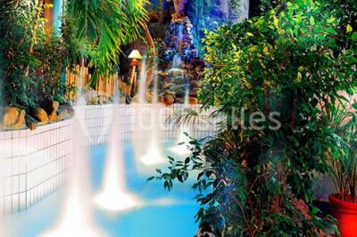 Salle de réception avec tables hautes noires, verres lumineux et éclairage tamisé dans une ambiance festive.