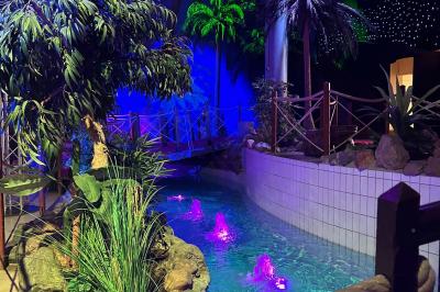 Salle de réception avec tables hautes noires, verres lumineux et éclairage tamisé dans une ambiance festive.