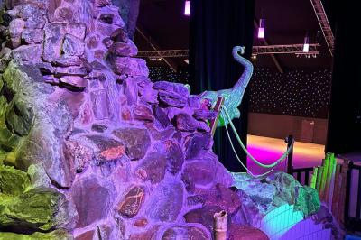 Salle de réception avec tables hautes noires, verres lumineux et éclairage tamisé dans une ambiance festive.