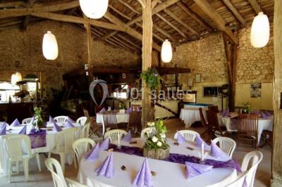 Terrains de tennis extérieurs entourés de verdure, avec des joueurs en action sous un ciel dégagé.