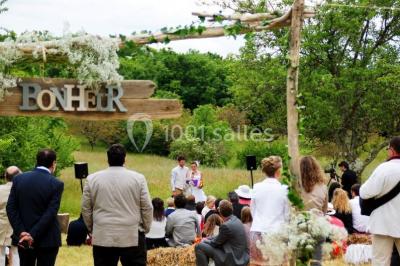 Terrains de tennis extérieurs entourés de verdure, avec des joueurs en action sous un ciel dégagé.