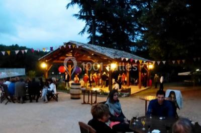 Terrains de tennis extérieurs entourés de verdure, avec des joueurs en action sous un ciel dégagé.
