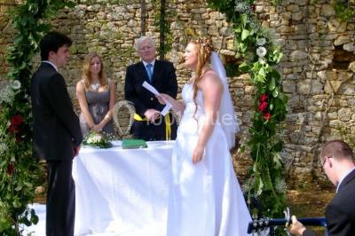 Terrains de tennis extérieurs entourés de verdure, avec des joueurs en action sous un ciel dégagé.