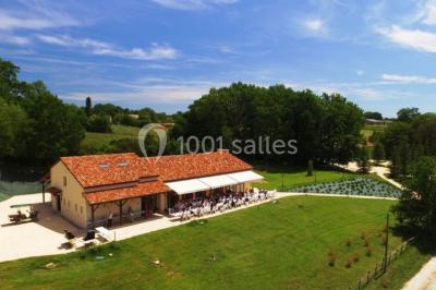 Terrains de tennis extérieurs entourés de verdure, avec des joueurs en action sous un ciel dégagé.