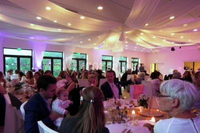 Terrains de tennis extérieurs entourés de verdure, avec des joueurs en action sous un ciel dégagé.