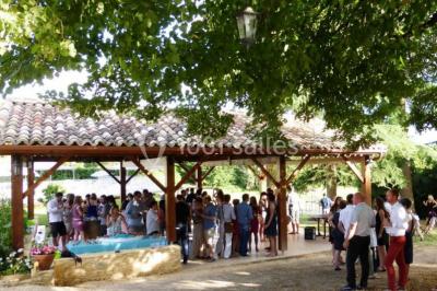 Terrains de tennis extérieurs entourés de verdure, avec des joueurs en action sous un ciel dégagé.