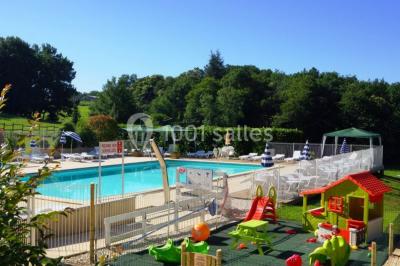 Terrains de tennis extérieurs entourés de verdure, avec des joueurs en action sous un ciel dégagé.