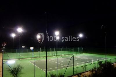Un groupe de personnes assises en cercle en plein air, discutant près d'un tableau blanc, entouré d'arbres.