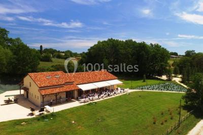 Un groupe de personnes assises en cercle en plein air, discutant près d'un tableau blanc, entouré d'arbres.