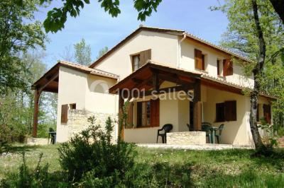 Un groupe de personnes assises en cercle en plein air, discutant près d'un tableau blanc, entouré d'arbres.