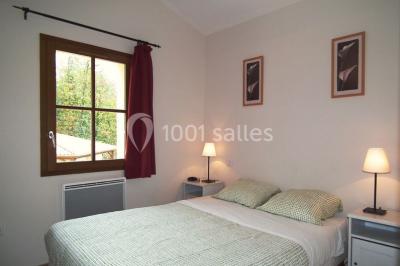 Un groupe de personnes assises en cercle en plein air, discutant près d'un tableau blanc, entouré d'arbres.