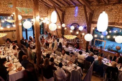 Un groupe de personnes assises en cercle en plein air, discutant près d'un tableau blanc, entouré d'arbres.