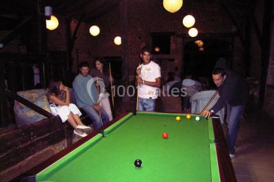 Un groupe de personnes assises en cercle en plein air, discutant près d'un tableau blanc, entouré d'arbres.