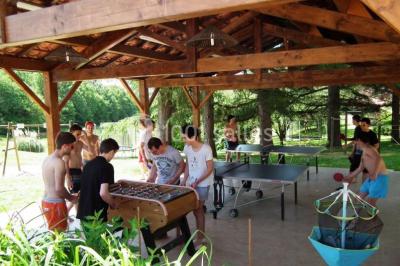 Un groupe de personnes assises en cercle en plein air, discutant près d'un tableau blanc, entouré d'arbres.