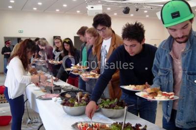 Un groupe de personnes assises en cercle en plein air, discutant près d'un tableau blanc, entouré d'arbres.