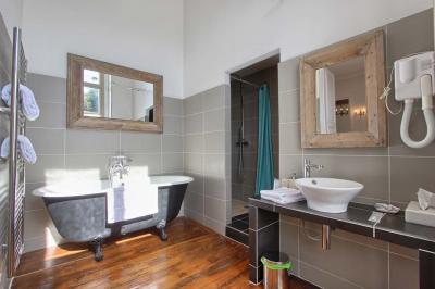 Façade d'un château entouré de jardins bien entretenus, avec un ciel nuageux en arrière-plan.