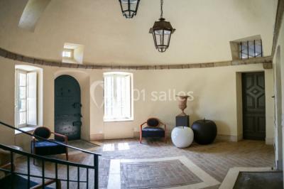 Dortoir lumineux avec plusieurs lits simples alignés, draps blancs et cartes géographiques accrochées aux murs.