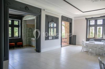 Dortoir lumineux avec plusieurs lits simples alignés, draps blancs et cartes géographiques accrochées aux murs.