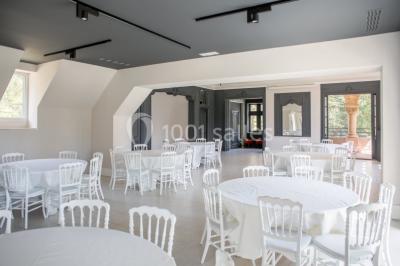 Dortoir lumineux avec plusieurs lits simples alignés, draps blancs et cartes géographiques accrochées aux murs.