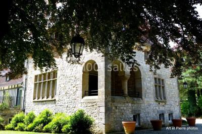 Dortoir lumineux avec plusieurs lits simples alignés, draps blancs et cartes géographiques accrochées aux murs.