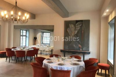 Dortoir lumineux avec plusieurs lits simples alignés, draps blancs et cartes géographiques accrochées aux murs.