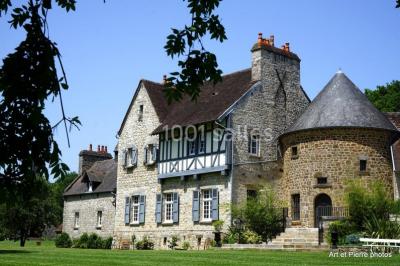 Dortoir lumineux avec plusieurs lits simples alignés, draps blancs et cartes géographiques accrochées aux murs.