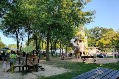 Espace extérieur décoré avec arche florale, deux chaises transparentes et fond blanc sous une tente.