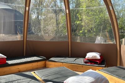 Espace extérieur décoré avec arche florale, deux chaises transparentes et fond blanc sous une tente.