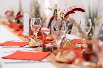 Espace extérieur décoré avec arche florale, deux chaises transparentes et fond blanc sous une tente.