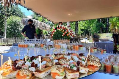 Espace extérieur décoré avec arche florale, deux chaises transparentes et fond blanc sous une tente.
