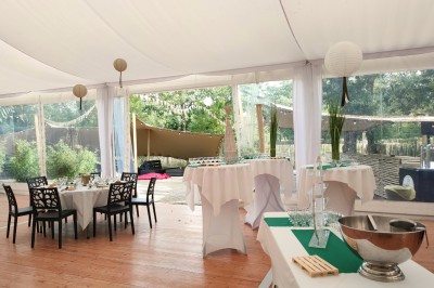 Table de buffet en extérieur avec verres de jus, desserts, fontaine à boisson et décorations festives.