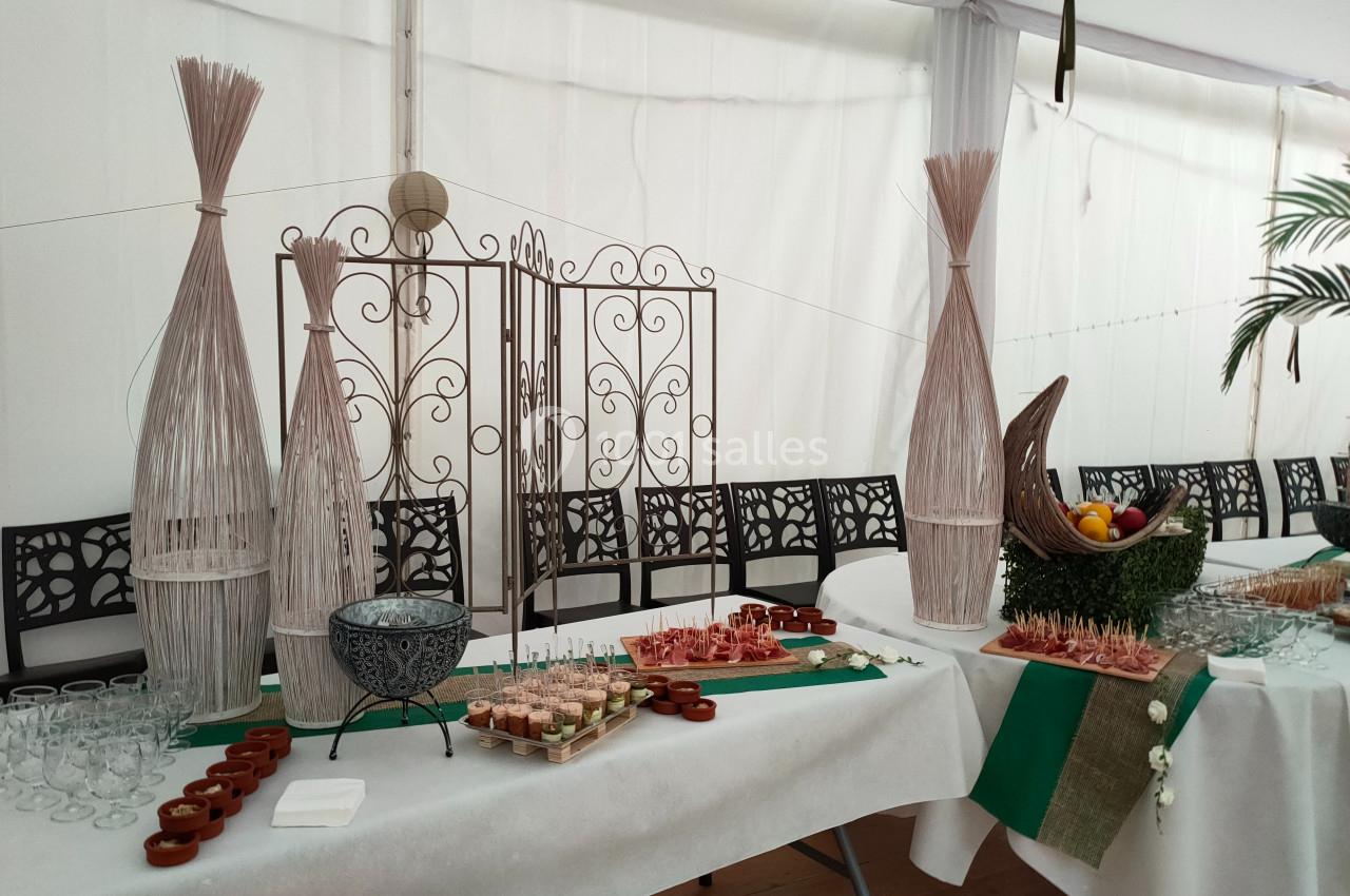 Table décorée pour un buffet avec des éléments naturels, des verrines, des fruits et des décorations en osier.