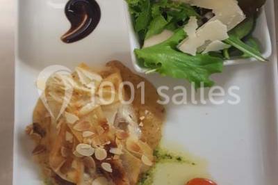 Assiette gastronomique avec un feuilleté garni, sauce, salade verte au parmesan et tomate cerise.