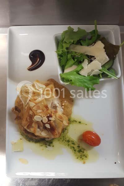Assiette gastronomique avec un feuilleté garni, sauce, salade verte au parmesan et tomate cerise.