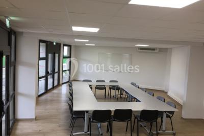 Terrasse d'un restaurant en bois avec vue sur un port de plaisance, tables occupées et végétation en premier plan.