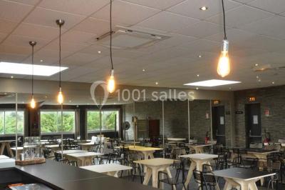 Salon avec cheminée en bois, mur en pierre, mobilier éclectique et éléments décoratifs comme bougies et lampadaire.