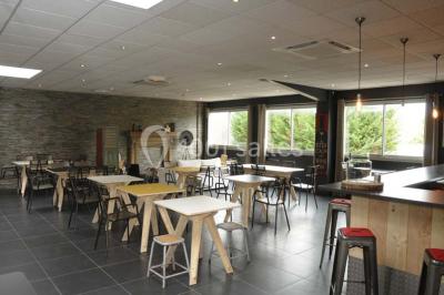 Salon avec cheminée en bois, mur en pierre, mobilier éclectique et éléments décoratifs comme bougies et lampadaire.