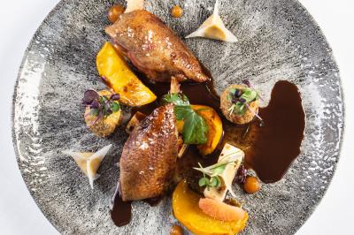 Dessert raffiné composé de fruits rouges, mousse, meringue et sorbet, présenté sur une assiette blanche.