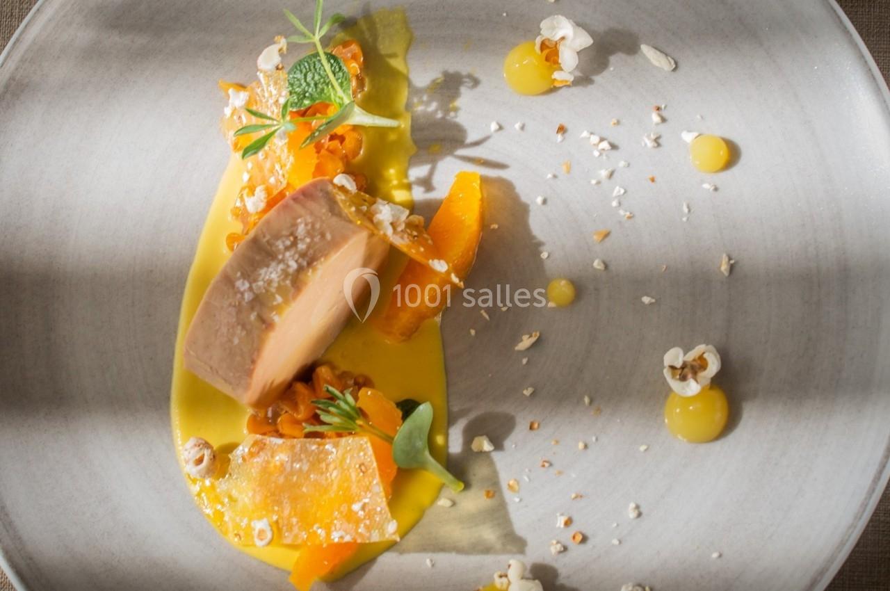 Assiette gastronomique avec foie gras, purée jaune, éclats de céréales et garniture de légumes colorés.