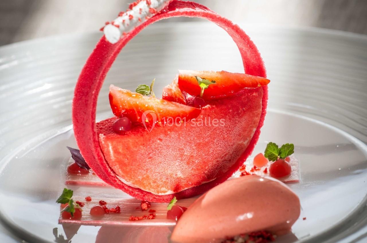 Dessert raffiné composé de fruits rouges, mousse, meringue et sorbet, présenté sur une assiette blanche.