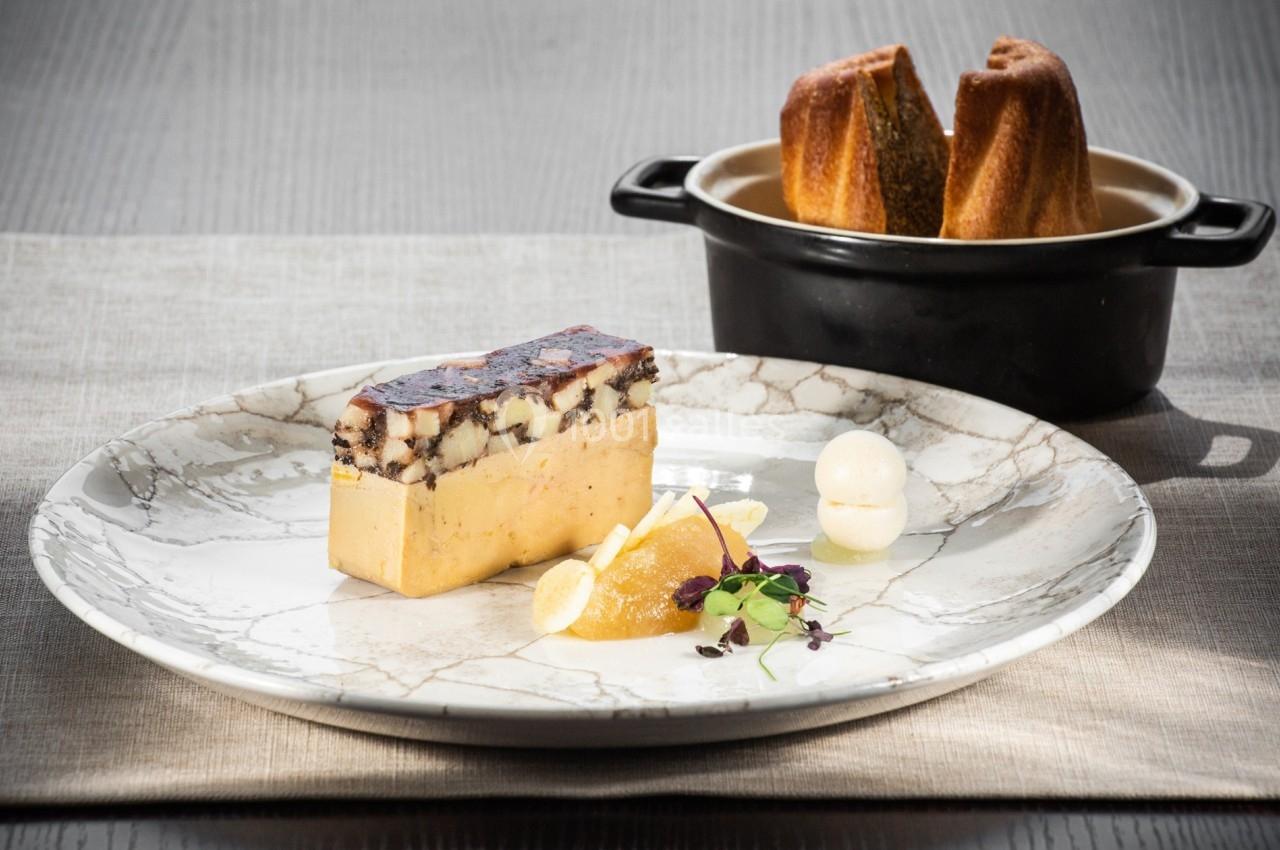 Terrine de foie gras avec gelée, garniture de fruits et micro-pousses, accompagnée de pain brioché.